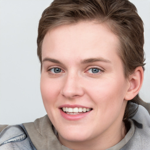 Joyful white young-adult female with short  brown hair and grey eyes