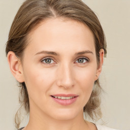 Joyful white young-adult female with medium  brown hair and grey eyes