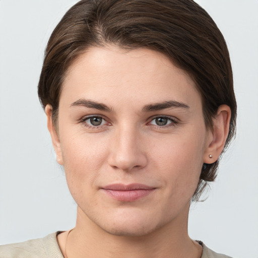 Joyful white young-adult female with short  brown hair and grey eyes