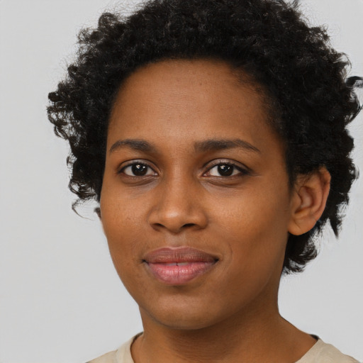 Joyful black young-adult female with short  brown hair and brown eyes