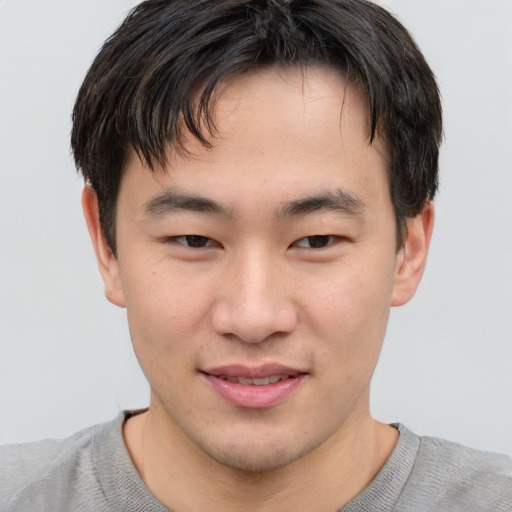 Joyful asian young-adult male with short  brown hair and brown eyes