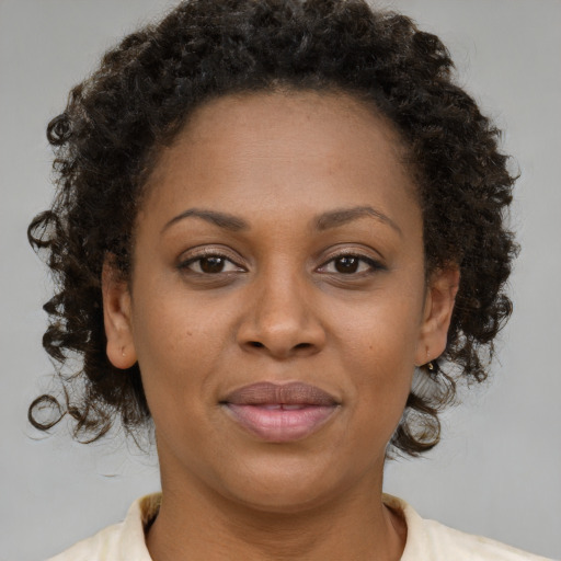 Joyful black adult female with short  brown hair and brown eyes
