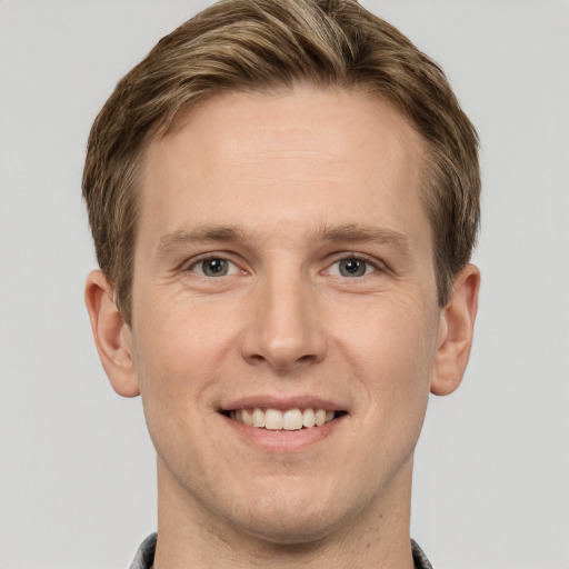 Joyful white young-adult male with short  brown hair and grey eyes