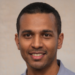 Joyful latino young-adult male with short  black hair and brown eyes