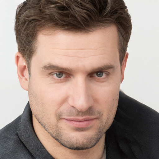 Joyful white young-adult male with short  brown hair and grey eyes