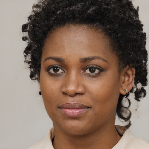 Joyful black young-adult female with short  brown hair and brown eyes