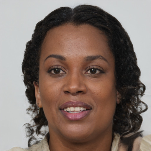 Joyful black adult female with medium  brown hair and brown eyes