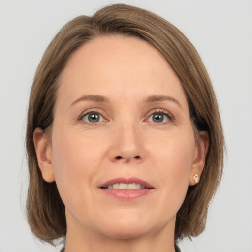 Joyful white adult female with medium  brown hair and grey eyes