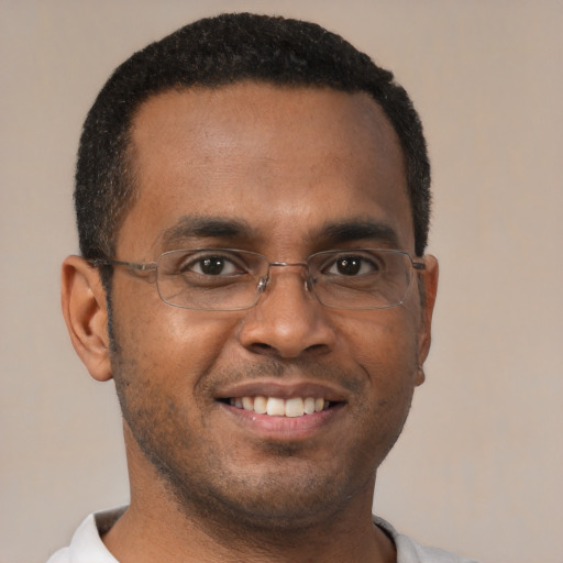 Joyful black young-adult male with short  brown hair and brown eyes