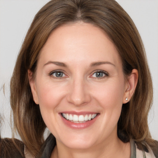 Joyful white adult female with medium  brown hair and grey eyes