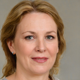 Joyful white adult female with medium  brown hair and blue eyes