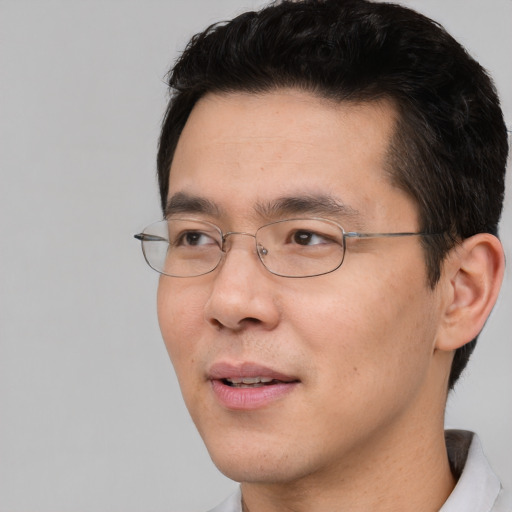 Joyful asian young-adult male with short  brown hair and brown eyes