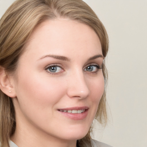 Joyful white young-adult female with medium  brown hair and blue eyes