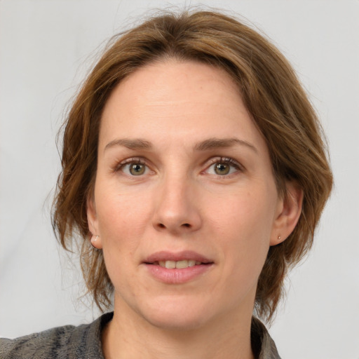 Joyful white adult female with medium  brown hair and grey eyes