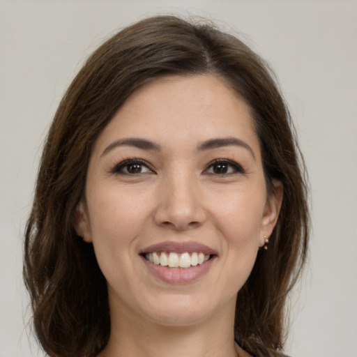 Joyful white young-adult female with long  brown hair and brown eyes