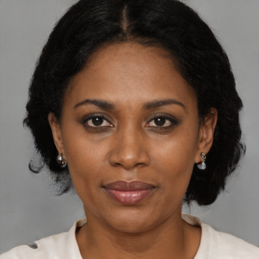 Joyful black adult female with medium  brown hair and brown eyes