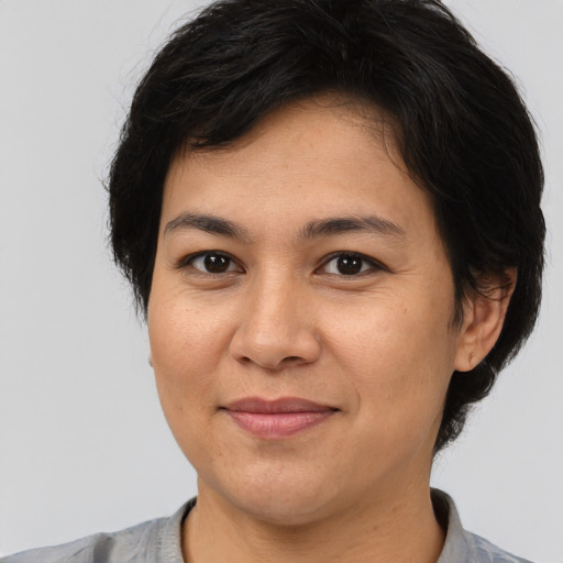 Joyful latino adult female with medium  brown hair and brown eyes