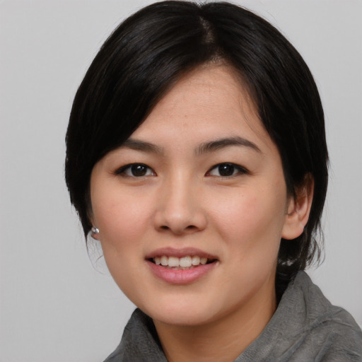 Joyful asian young-adult female with medium  black hair and brown eyes