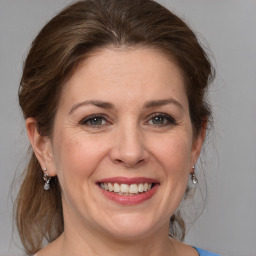 Joyful white adult female with medium  brown hair and grey eyes