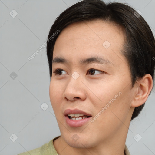 Joyful asian young-adult male with short  brown hair and brown eyes