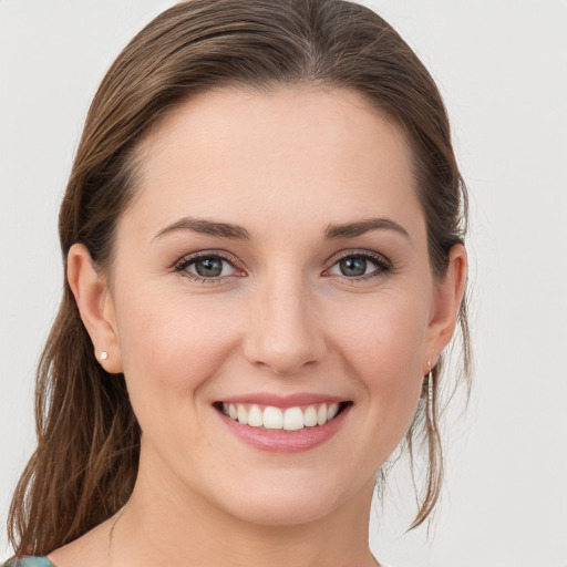 Joyful white young-adult female with medium  brown hair and grey eyes