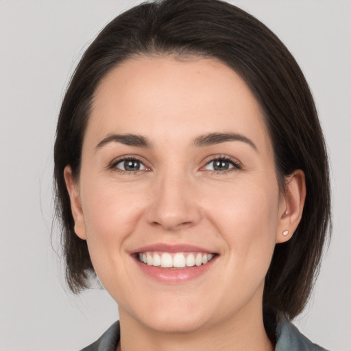 Joyful white young-adult female with medium  brown hair and brown eyes