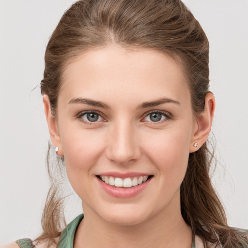 Joyful white young-adult female with medium  brown hair and grey eyes