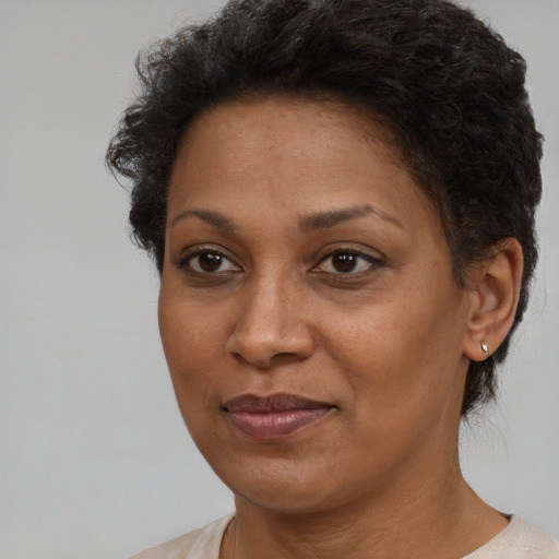 Joyful black adult female with short  brown hair and brown eyes