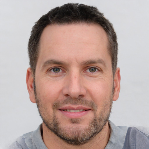 Joyful white adult male with short  brown hair and grey eyes