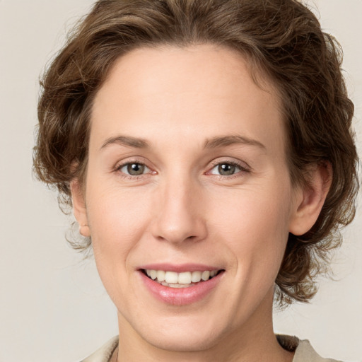 Joyful white young-adult female with medium  brown hair and green eyes