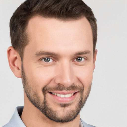 Joyful white young-adult male with short  brown hair and grey eyes