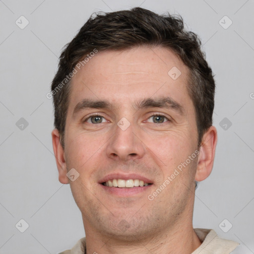 Joyful white young-adult male with short  brown hair and grey eyes