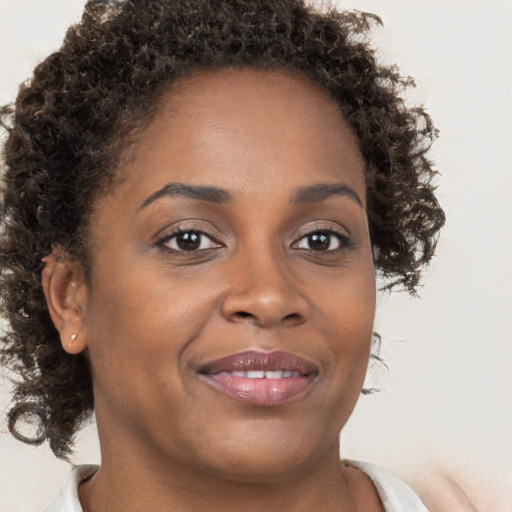 Joyful black young-adult female with medium  brown hair and brown eyes