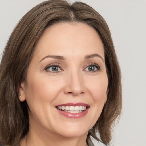 Joyful white adult female with medium  brown hair and brown eyes