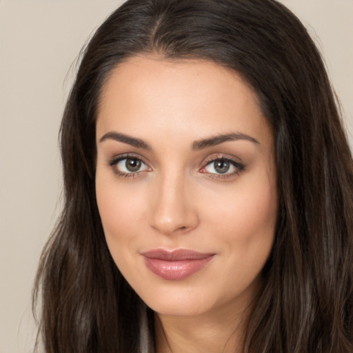 Joyful white young-adult female with long  brown hair and brown eyes