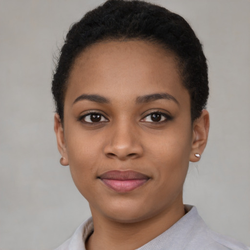 Joyful black young-adult female with short  black hair and brown eyes