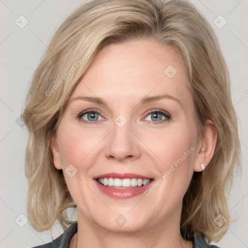 Joyful white adult female with medium  brown hair and blue eyes