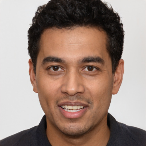 Joyful white young-adult male with short  black hair and brown eyes