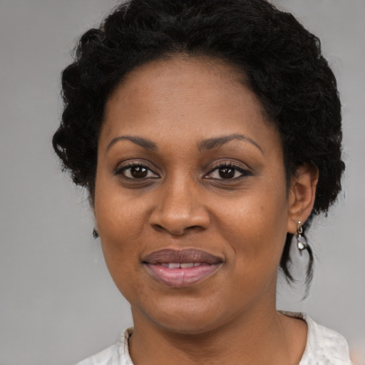 Joyful black adult female with medium  black hair and brown eyes
