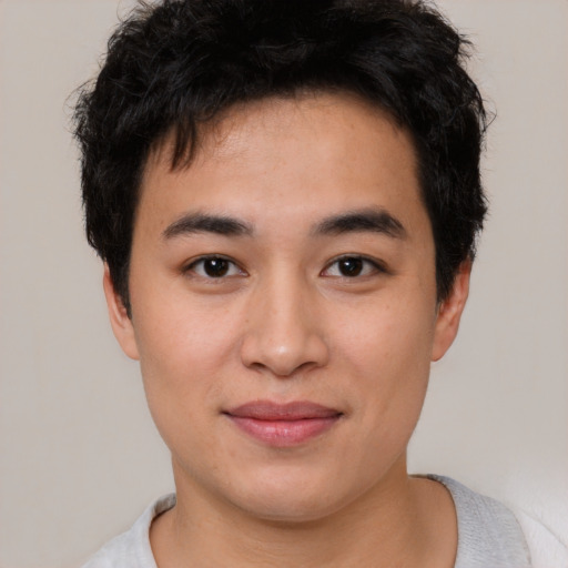 Joyful asian young-adult male with short  brown hair and brown eyes