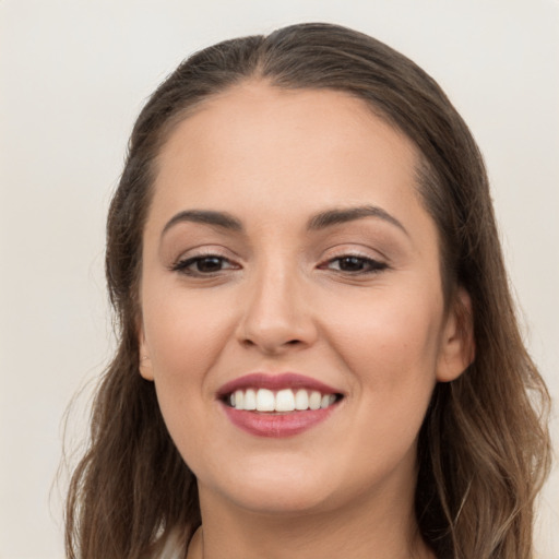 Joyful white young-adult female with long  brown hair and brown eyes