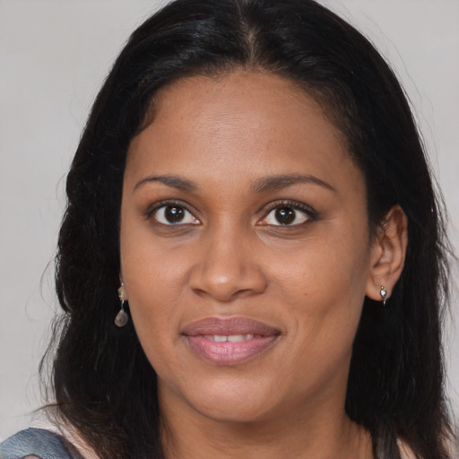 Joyful black young-adult female with long  brown hair and brown eyes