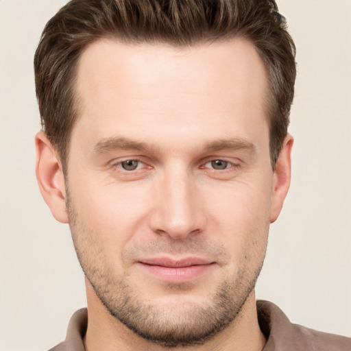 Joyful white young-adult male with short  brown hair and grey eyes