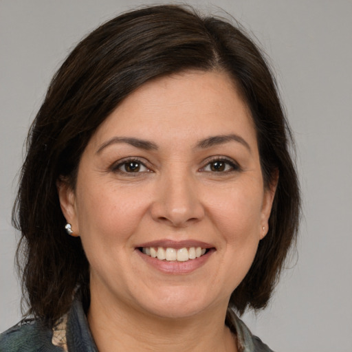 Joyful white adult female with medium  brown hair and brown eyes