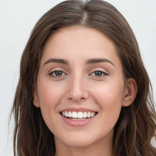 Joyful white young-adult female with long  brown hair and grey eyes