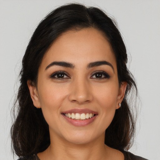 Joyful latino young-adult female with long  brown hair and brown eyes