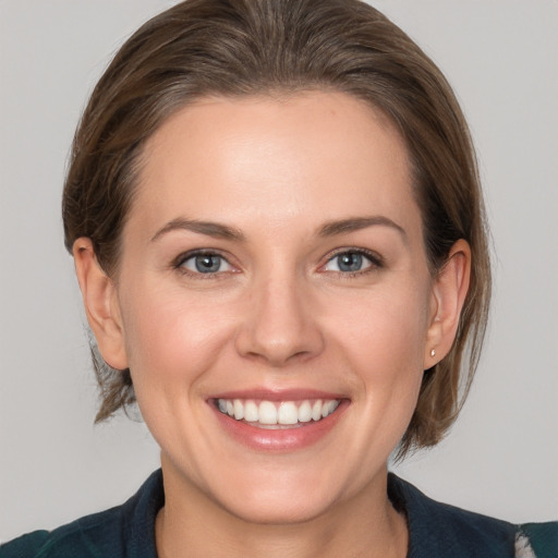 Joyful white young-adult female with medium  brown hair and grey eyes