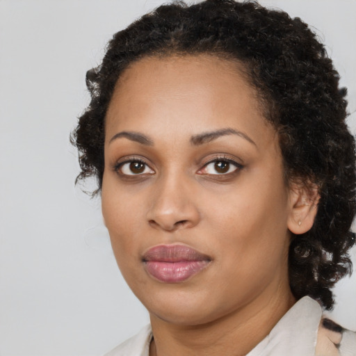 Joyful black young-adult female with medium  black hair and brown eyes