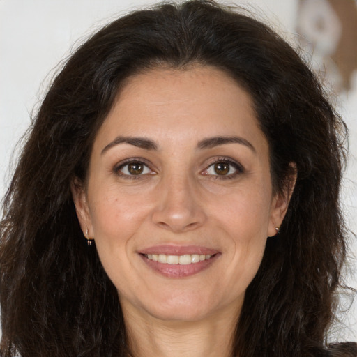 Joyful white adult female with long  brown hair and brown eyes