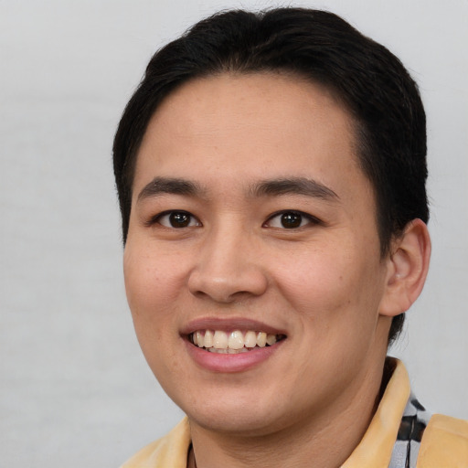Joyful asian young-adult male with short  brown hair and brown eyes